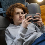 teenage-boy-using-smartphone-home