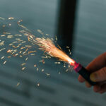 Burning Firecracker with Sparks. Guy Holding a Petard in a Hand