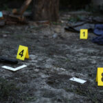 Evidence with yellow CSI marker for evidence numbering on the residental backyard in evening. Crime scene investigation concept