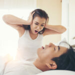 Young woman bored with her boyfriend snoring