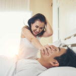Young woman bored with her boyfriend snoring