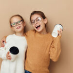 two little girls with disposable glasses in their hands