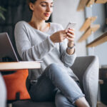 Woman sitting in a cafe drinking coffee and working on a computer