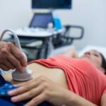 Woman getting ultrasound of a abdomen from doctor