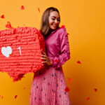 Cheerful girl with pretty smile posing with red bunner. Studio s