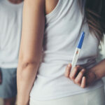Happy couple smiling after find out positive pregnancy test in b